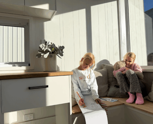 TCs kids 2 Two girls playing inside a Nexus Communities modular pod home, part of a social impact housing project in Australia